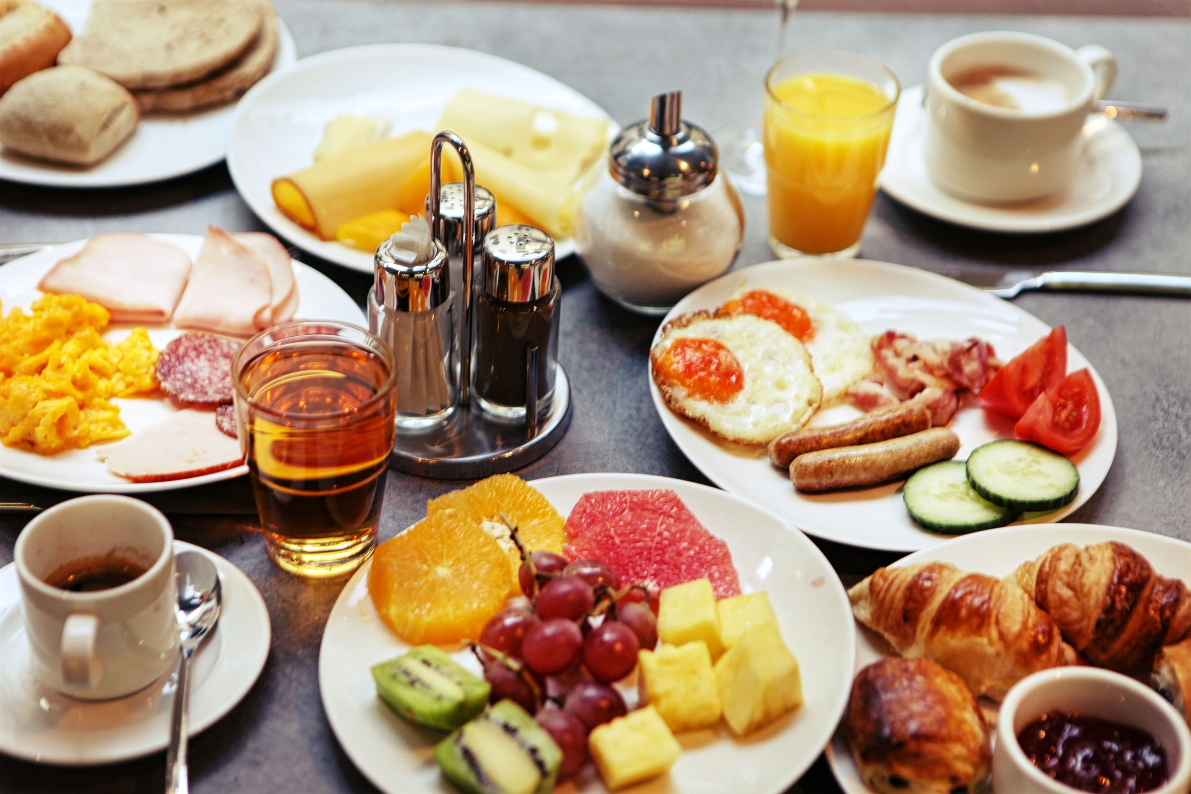 Una mesa con una variedad de alimentos y bebidas para el desayuno.