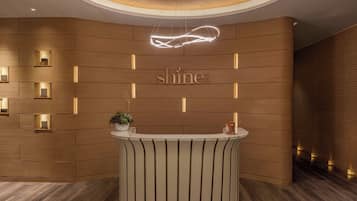Welcome to our reception area, featuring a curved reception desk and wooden panel walls with embedded lights.