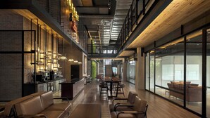 Un interior moderno con una barra larga, una zona de estar y ventanas amplias.