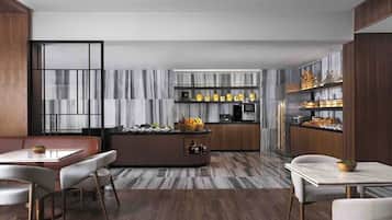 A modern kitchen with a central island, built-in cabinets, and a marble backsplash.