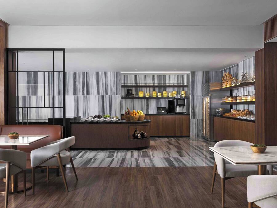 A modern kitchen with a central island, built-in cabinets, and a marble backsplash.
