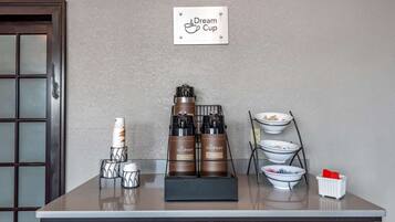 A coffee station with a coffee machine, cups, and a sign that reads "Dream Cup".