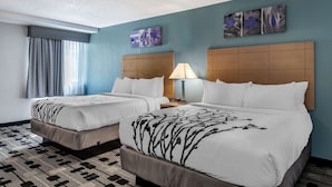 A hotel room with two beds, a large window with curtains, a headboard with a lamp, and artwork on the wall. - Sleep Inn Terre Haute University Area (Terre Haute)