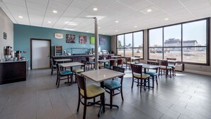 A spacious indoor dining area with multiple tables and chairs, a coffee station, and large windows offering a view of the outside. - Sleep Inn Terre Haute University Area (Terre Haute)
