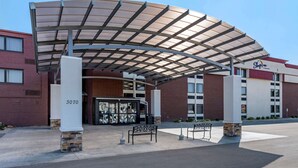 A hotel entrance with a covered walkway, a bench, and a stone pillar with the number 3070. - Sleep Inn Terre Haute University Area (Terre Haute)