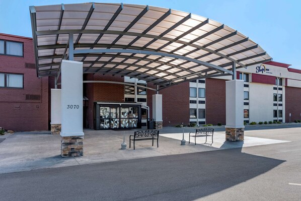 A hotel entrance with a covered walkway, a bench, and a stone pillar with the number 3070. - Sleep Inn Terre Haute University Area (Terre Haute)