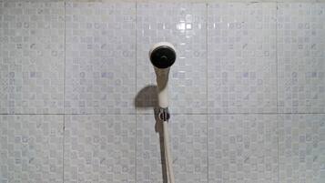 Een douchekop bevestigd aan een betegelde muur met een patroon.