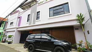 Une maison moderne à deux étages, avec un VUS noir garé dans l’allée.