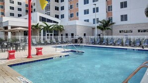 A hotel pool area with a clear blue pool, sun loungers, and palm trees. - Residence Inn by Marriott Fort Lauderdale Coconut Creek (Coconut Creek)