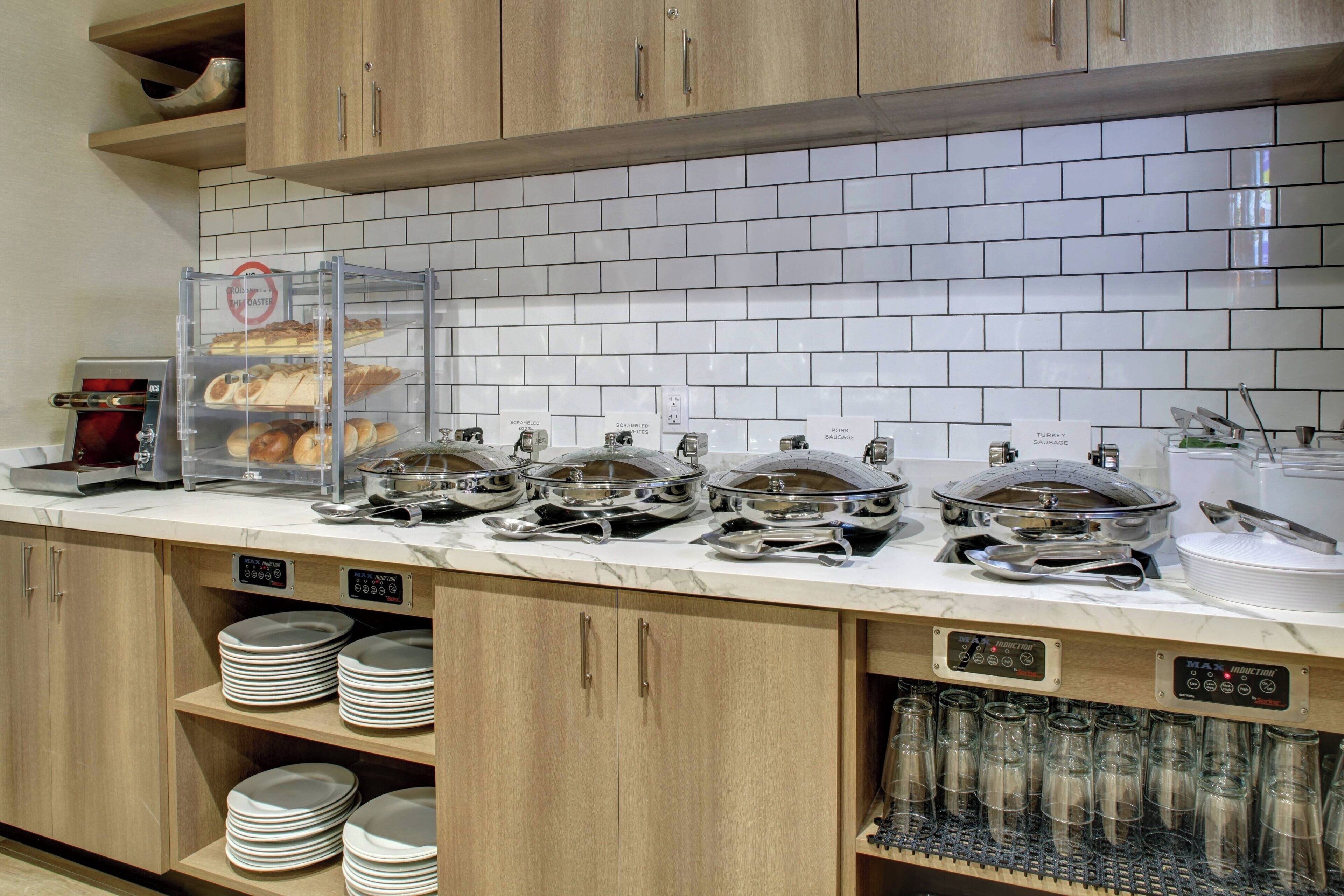 Un buffet avec différents stands de nourriture, notamment un présentoir à pains et un stand de viandes.
