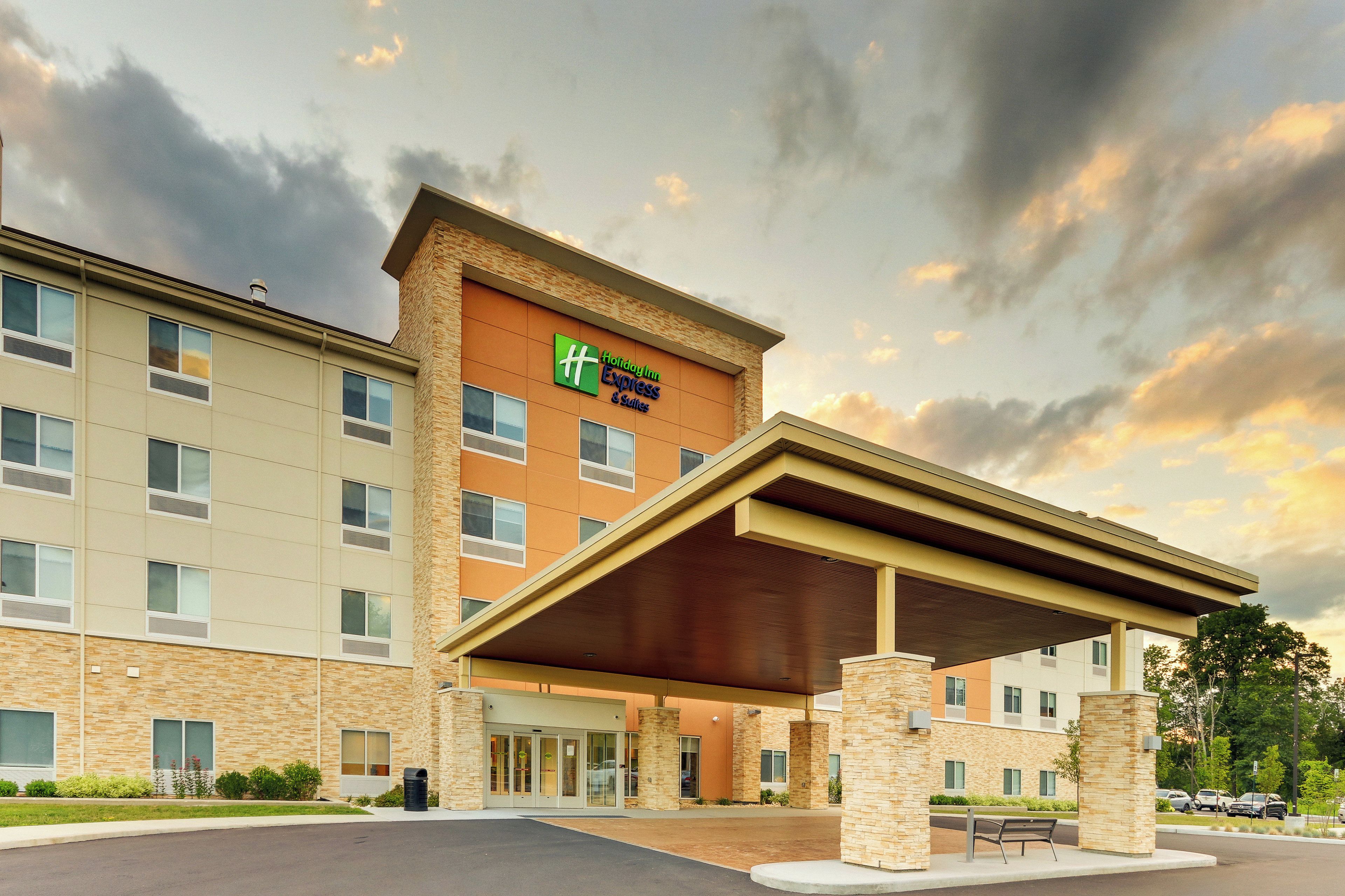 Un hotel Holiday Inn Express & Suites con entrada cubierta y estacionamiento.