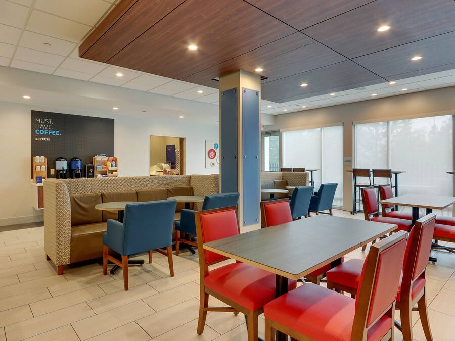 Una cafeteria moderna amb zones d'estar, una estació de cafè i vistes a través de grans finestres.
