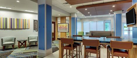 A modern interior with a bar area, seating, and artwork on the walls.
