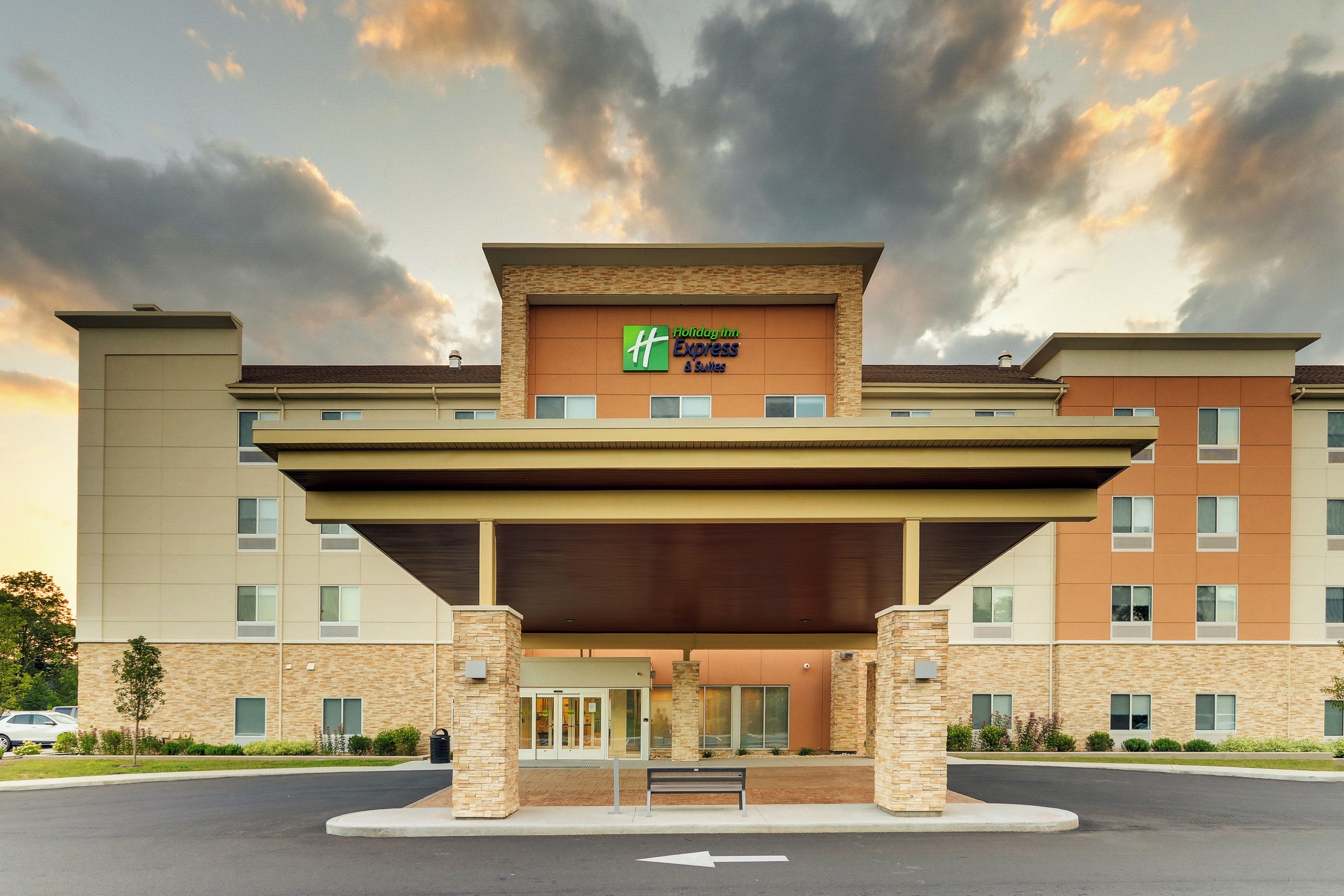 Un hotel Holiday Inn Express & Suites con entrada cubierta y fachada de ladrillo.