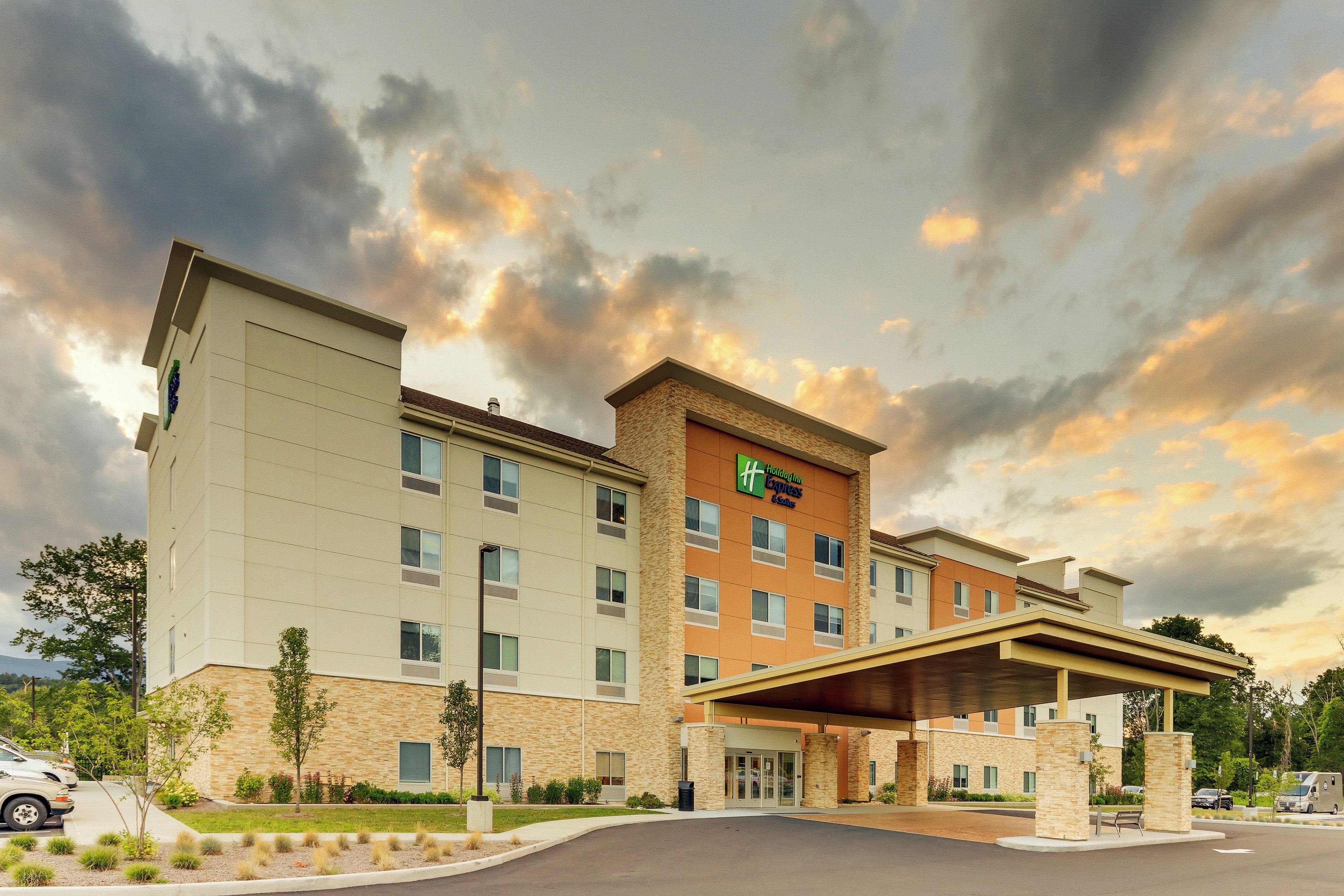 A Holiday Inn Express hotel with a modern design, featuring a covered entrance and a parking lot.