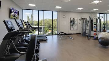 A gym with treadmills, weight machines, and exercise balls.