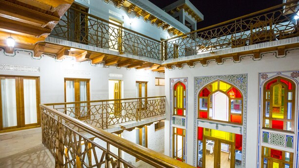 A multi-level building with ornate balconies and stained glass windows. - Hotel Volida Boutique (Bukhara)