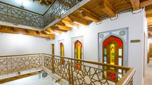 A multi-level interior with wooden beams and a balcony railing. - Hotel Volida Boutique (Bukhara)