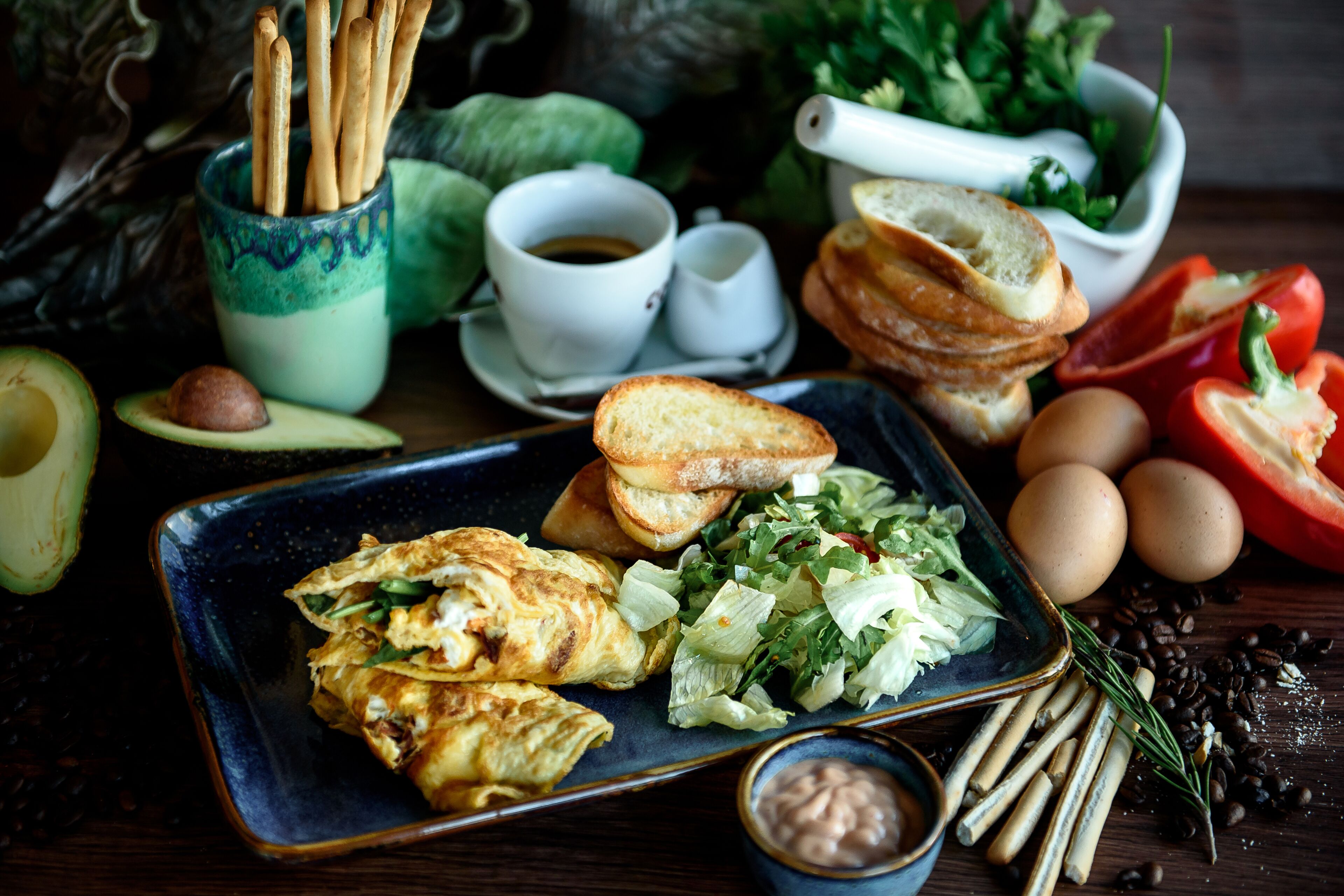 A breakfast plate with eggs, toast, avocado, and salad.