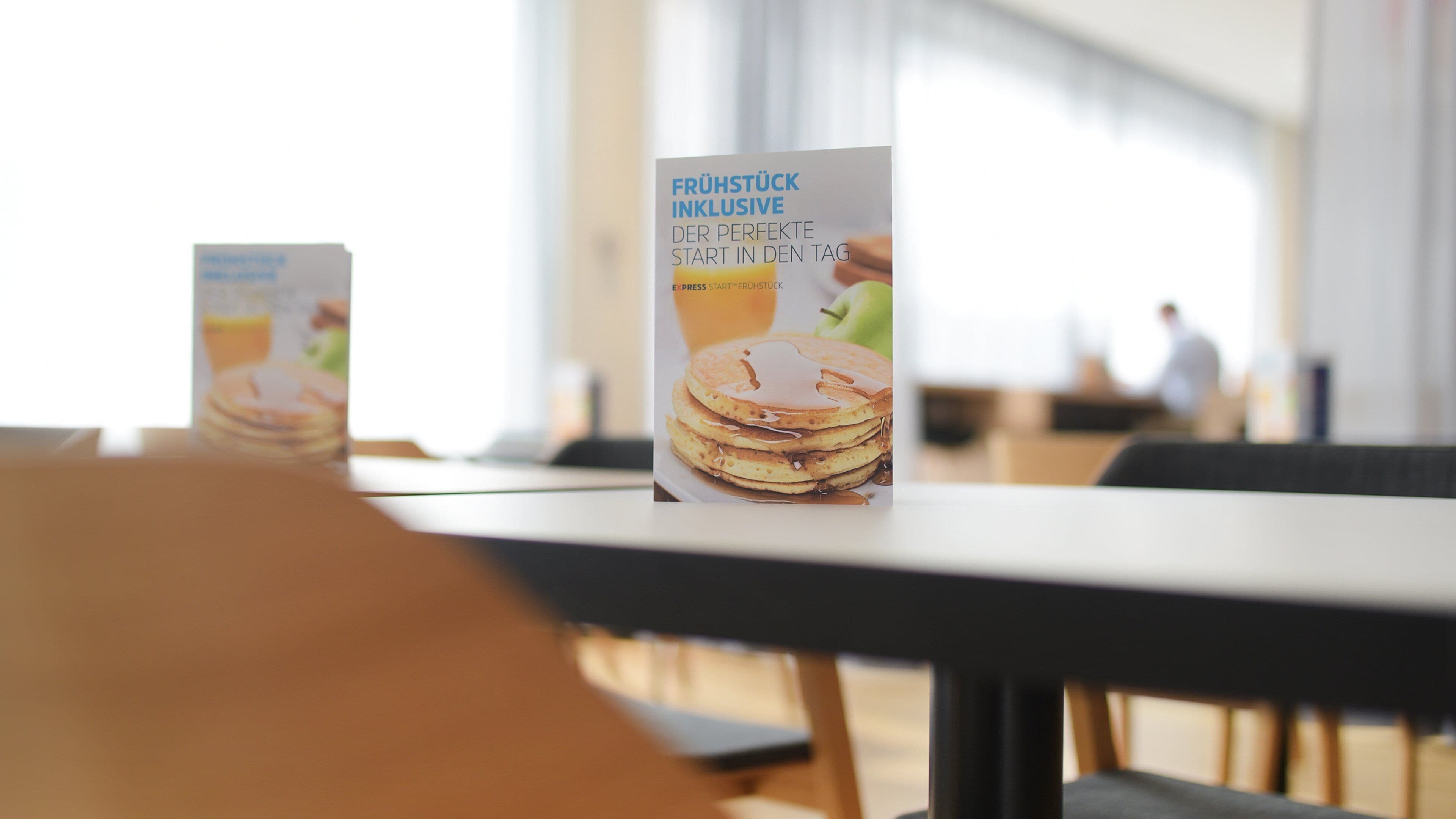 A menu board with breakfast options in a cafe setting.