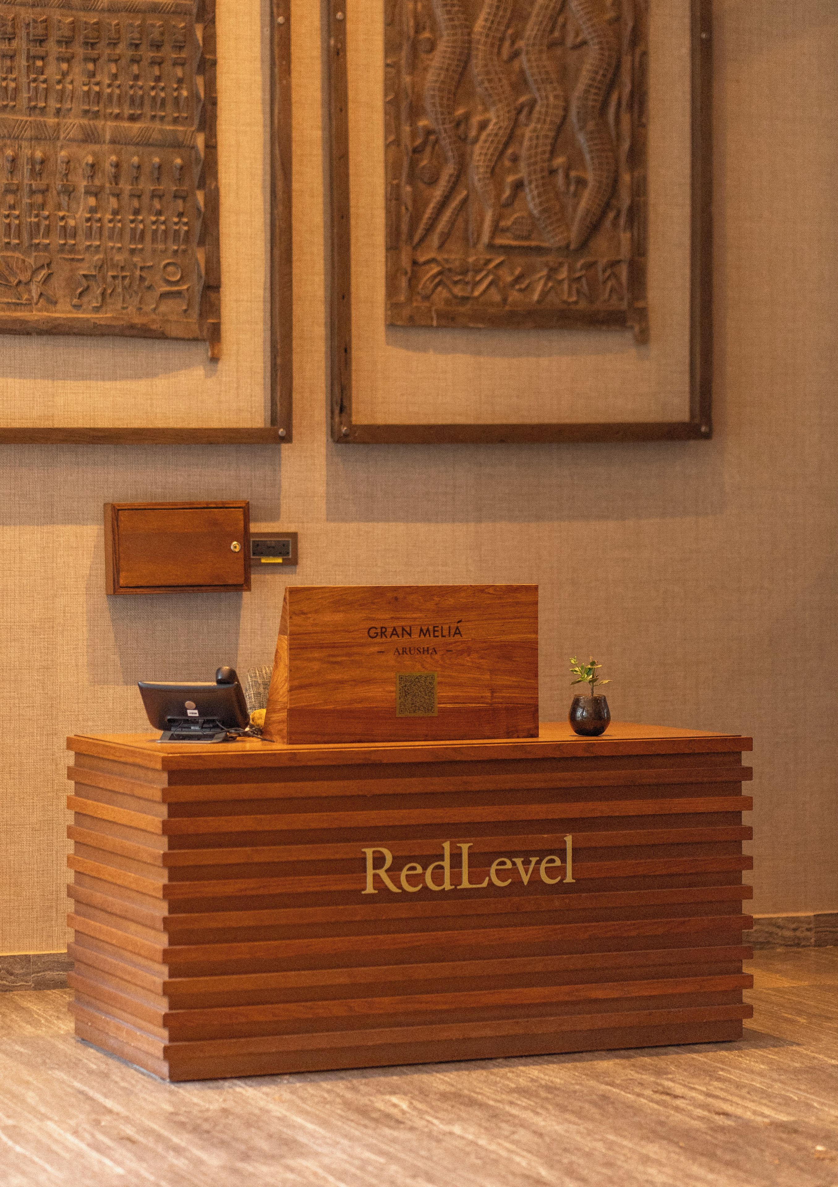 Un comptoir d’accueil avec un revêtement en bois et l’inscription « RedLevel » gravée dessus.
