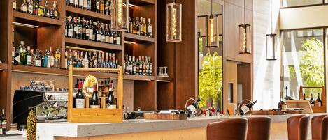A bar area with shelves of bottles, a counter, and bar stools.