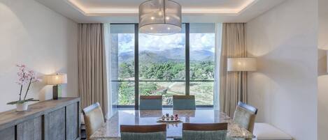 A dining area with a table, chairs, and a view of the outdoors.