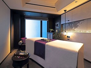 A modern hotel room with a bed, a small table with toiletries, a potted plant, and a view of the outside. - Dhawa Yura Kyoto (Kyoto)