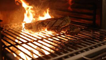 A grill with meat being cooked over an open flame.
