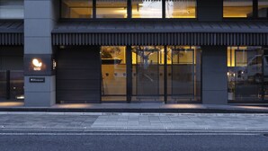 A modern building with a glass facade, a visible entrance, and a sign for "DHAWA TUSK STUDIO". - Dhawa Yura Kyoto (Kyoto)