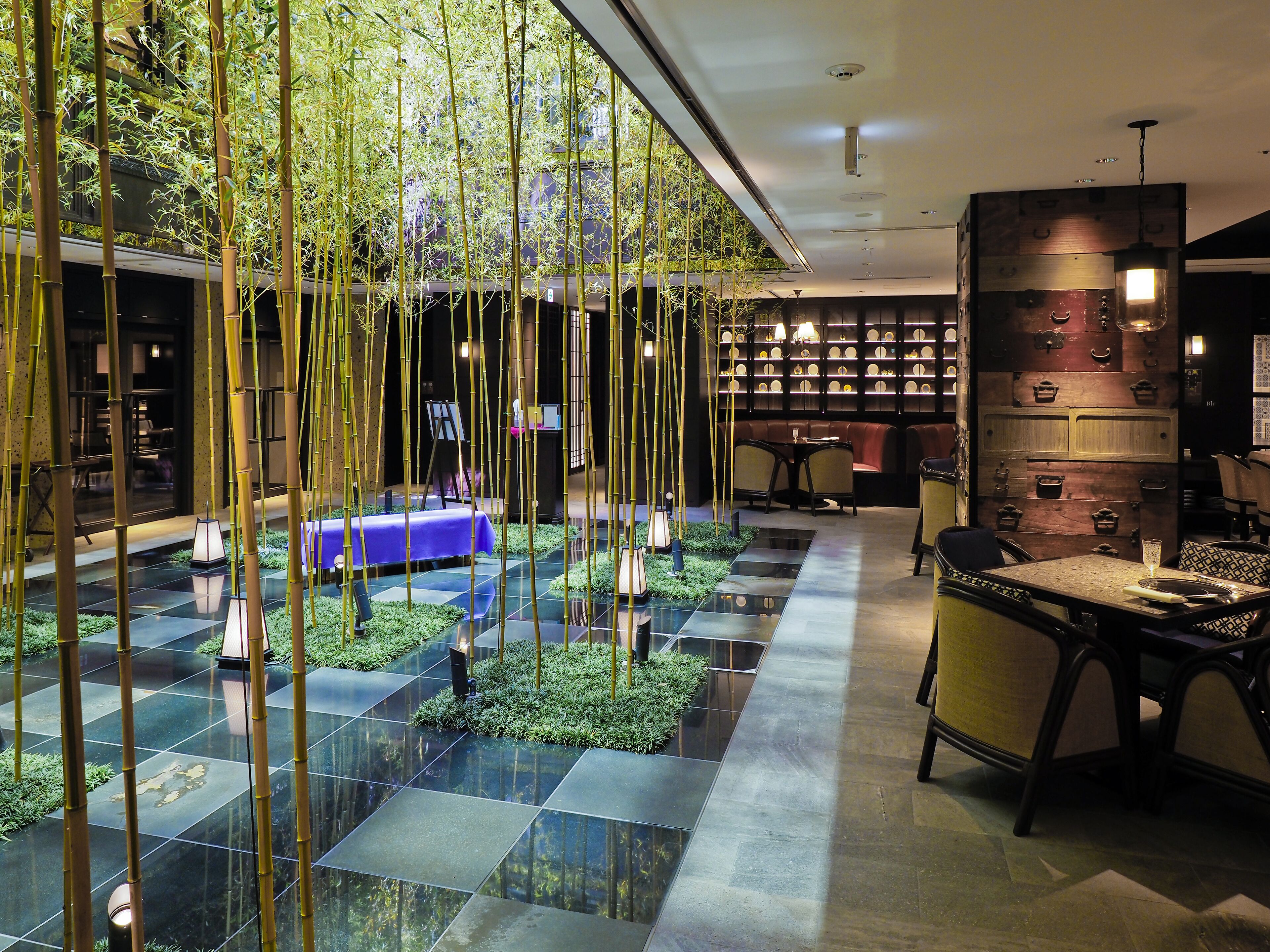 A modern interior with a dining area, a seating area, and a wall with decorative elements.