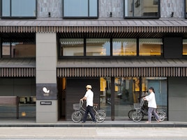A modern building with a flat facade, large windows, and a visible entrance.