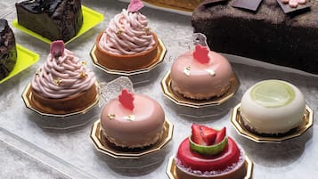 A variety of cakes on a table with different shapes and decorations.