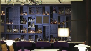 A bar area with a chandelier, purple seating, and a variety of liquor bottles. - Dhawa Yura Kyoto (Kyoto)