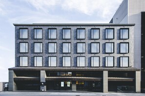 A modern building with a flat facade, multiple windows, and a covered entrance area. - Dhawa Yura Kyoto (Kyoto)
