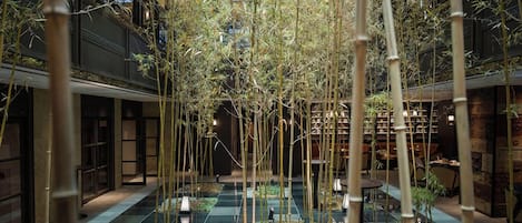 A bamboo grove with lanterns in a courtyard.