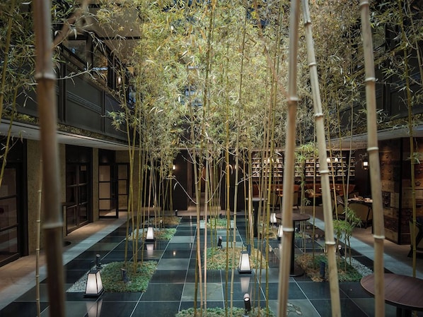 A bamboo grove with lanterns in a courtyard.
