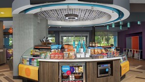 A self-service beverage station with a variety of drinks, snacks, and a refrigerated section. - Tru by Hilton Lake City (Lake City)