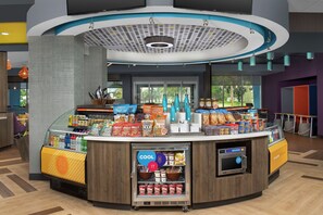 Eine Selbstbedienungsstation mit verschiedenen Getränken, Snacks und einem Kühlabteilung.