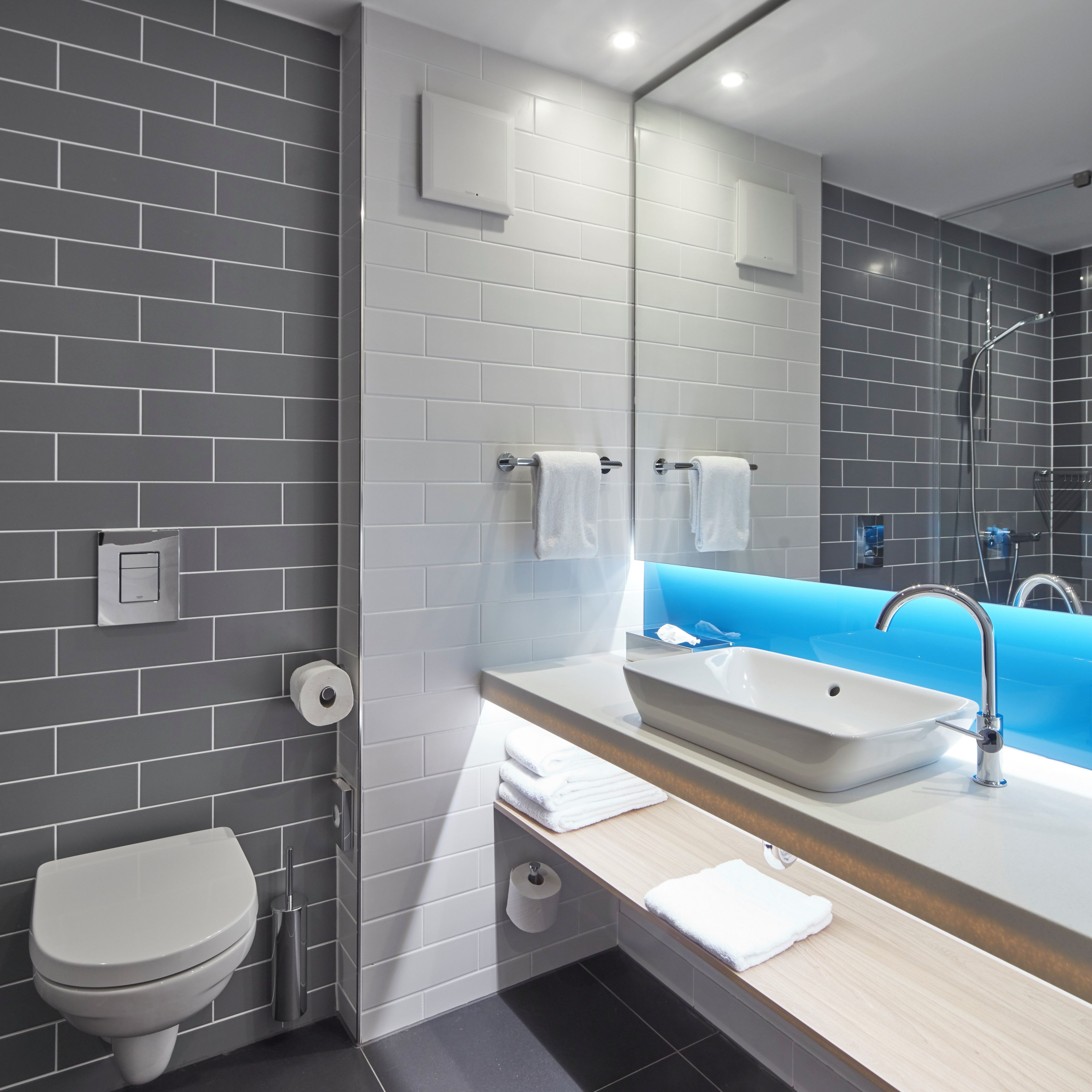 Ein modernes Badezimmer mit Toilette, Waschbecken und Dusche.