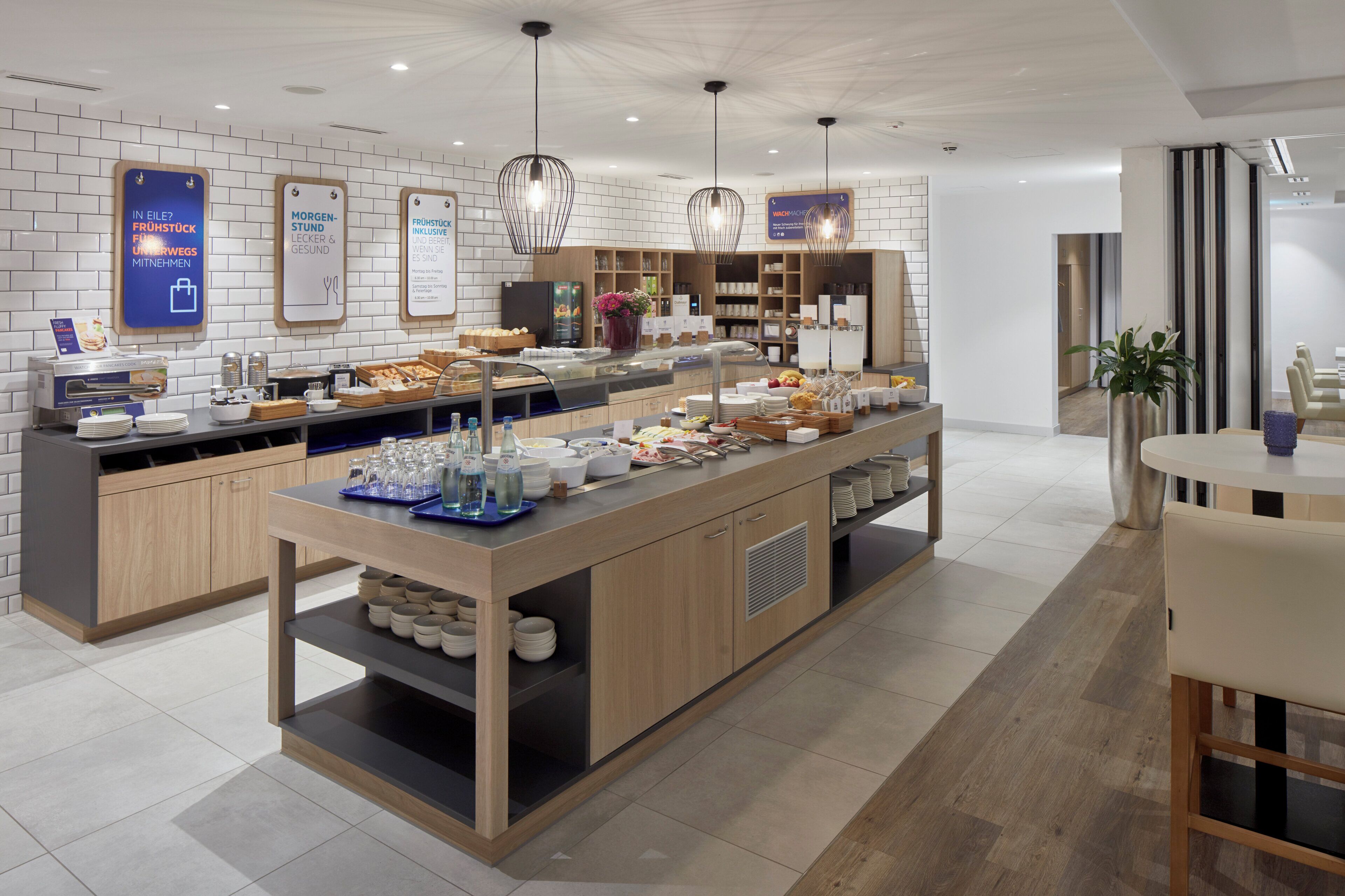 A modern breakfast buffet with a variety of food options, a coffee station, and a seating area with a table and chairs.