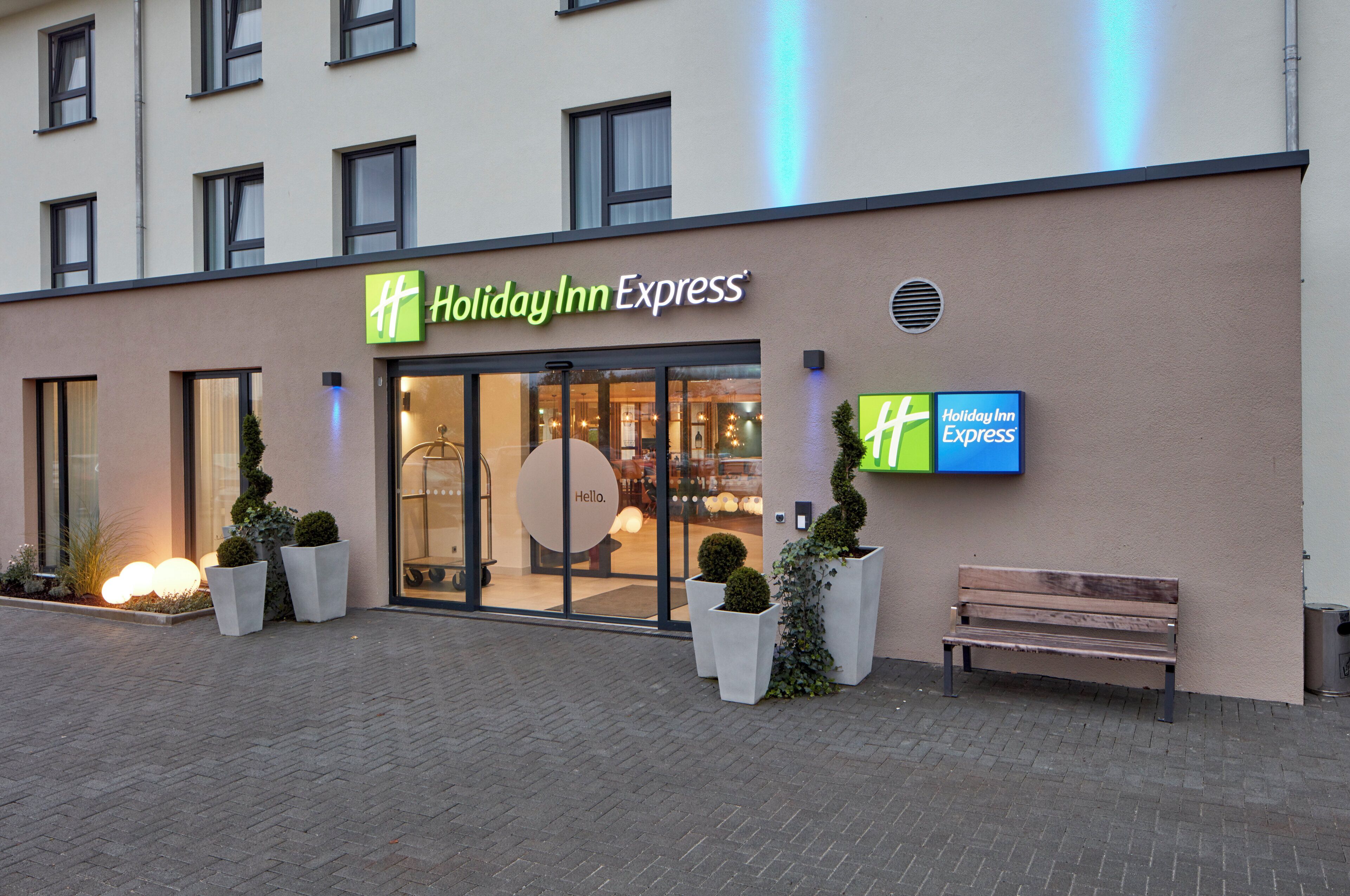 Un hotel Holiday Inn Express con fachada moderna, amplias ventanas y una entrada acogedora.