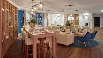 A modern interior with a dining area, sofas, and a TV screen.