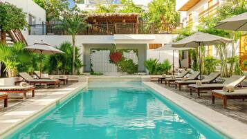 Una piscina al aire libre, sillones reclinables de piscina