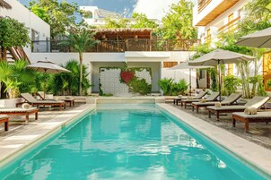 Una piscina al aire libre, sillones reclinables de piscina