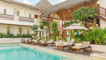 Una piscina al aire libre, sillones reclinables de piscina