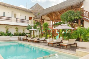 Una piscina al aire libre, sillones reclinables de piscina