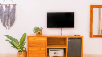 Un mueble de madera con un televisor, un refrigerador pequeño y una planta.
