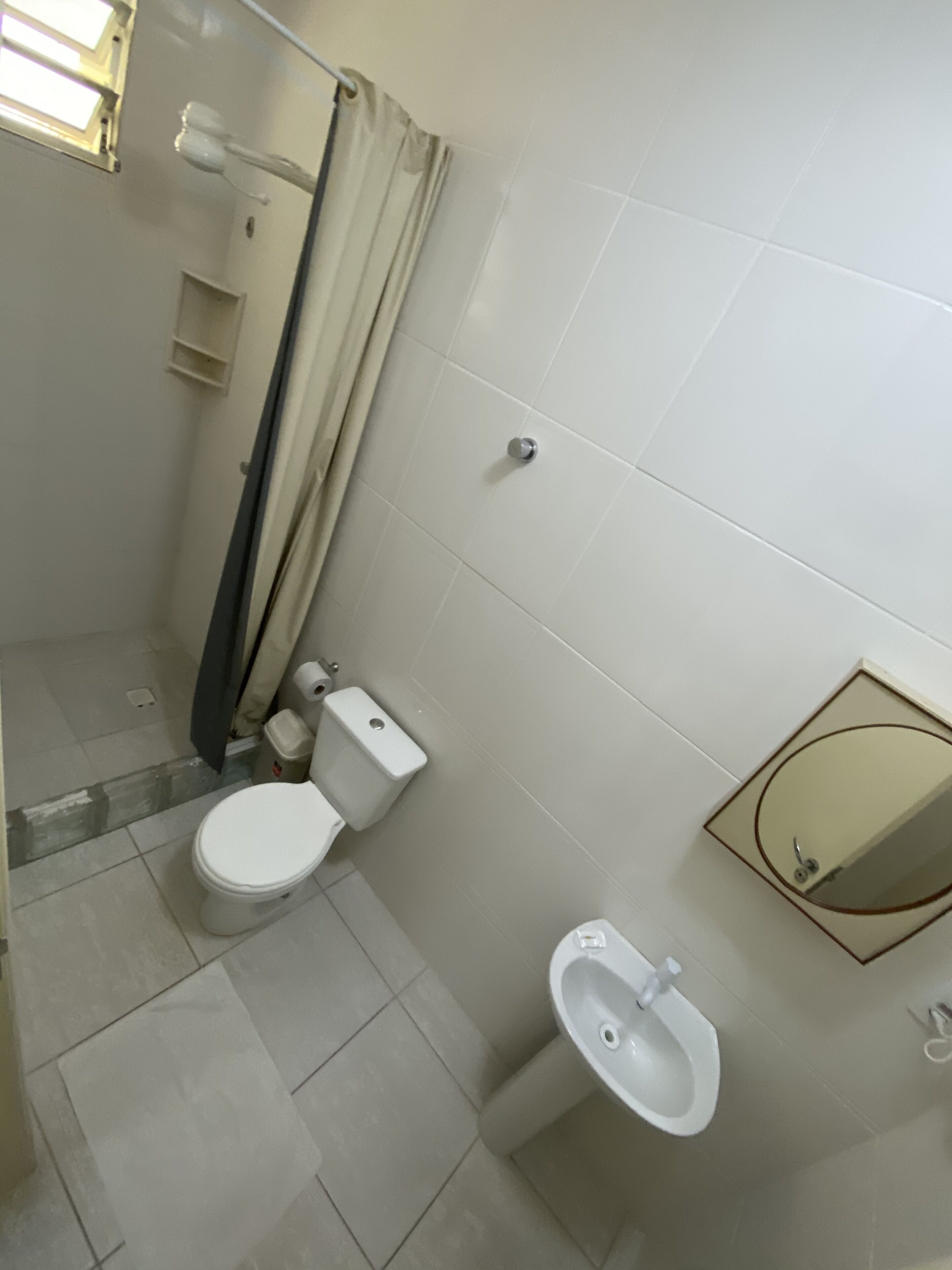 A bathroom with a toilet, bidet, and a mirror.