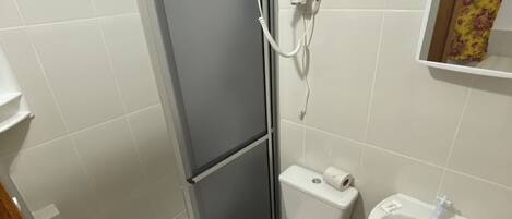 A bathroom with a toilet, sink, and shower.